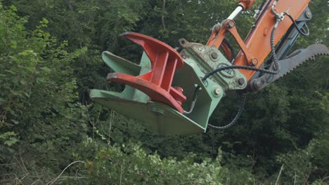 Tree-shear-attachment-on-digger-excavator-moves-into-forest