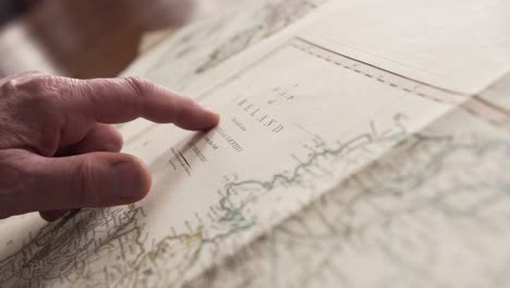 A-man-looks-over-some-old-Northern-Irish-historical-maps-in-a-library-in-Belfast