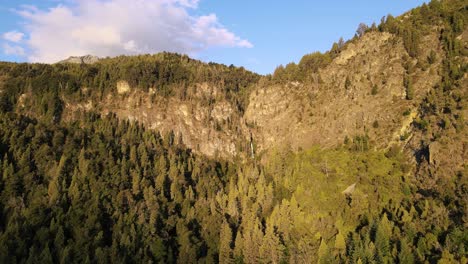 Lufttransportwagen-über-Mit-Zypressenwäldern-Bedeckten-Bergen-Und-Dem-Wasserfall-Corbata-Blanca-Im-Hintergrund-Bei-Sonnenuntergang,-Patagonien,-Argentinien