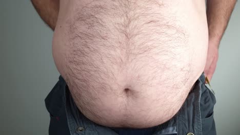 Overweight-man-measures-his-waistline