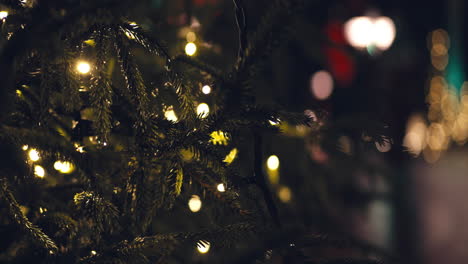 Christmas-tree's-branches-with-light-and-colorful-light-on-background