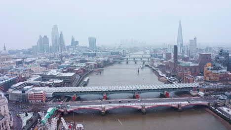 London-snow-aerial-dolly-forward-drone-shot-towards-iconic-city-centre-and-river-thames