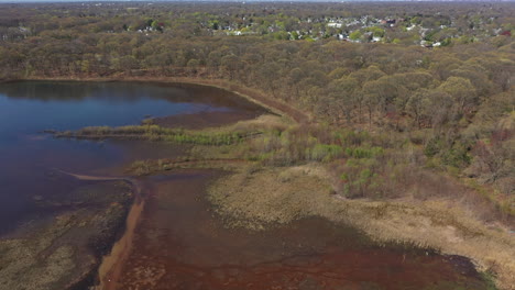 An-aerial-view-of-an-orange-colored-lake-during-the-day