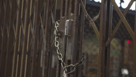 Iron-lattice-door-locked-with-metal-chain-and-padlock