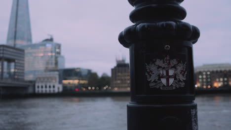 Das-Emblem-Der-Stadt-London-Auf-Einem-Laternenpfahl-Und-Die-Scherbe-Im-Hintergrund