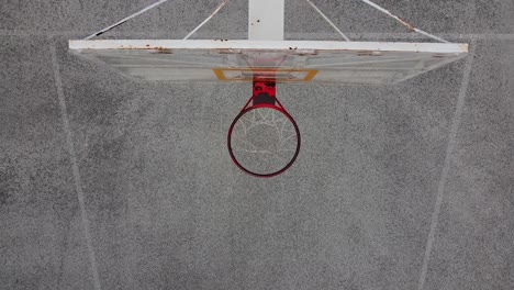Overhead-view-of-a-basketball-net-as-a-man-comes-in-for-a-layup