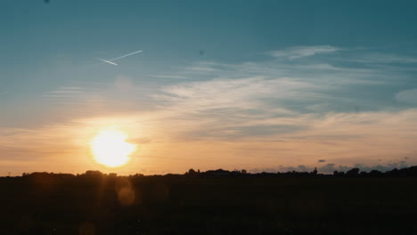 Zeitraffer-Eines-Wunderschönen-Sonnenuntergangs-Mit-Einigen-Wolken-Und-Flugzeugen,-Die-Den-Himmel-überqueren