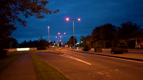 View-of-the-intersection,-night-and-illuminated-road,-passing-car-in-Dundalk,-Ireland