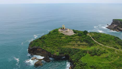 Aerial-orbiting-around-Fish-Statue-Yungyang-Hill-on-cliff-at-Krakal-coast,-Java