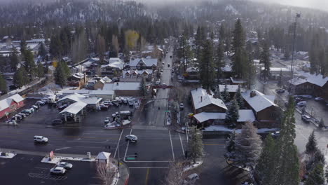 Aerial-over-snow-covered-buildings-in-town-center-of-Big-Bear-during-winter,-Drone-Christmas-town