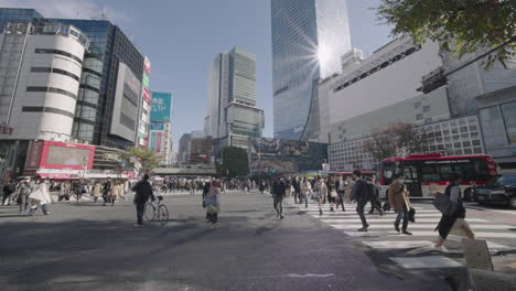 Während-Einer-Pandemie-überqueren-Menschen-Den-Belebten-Shibuya-Kreuzung-Mit-Hochhäusern-Und-Einem-Einkaufszentrum-Im-Hintergrund-In-Tokio,-Japan