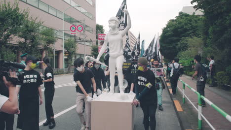 Manifestantes-Empujando-El-Carro-De-Madera-Con-La-Estatua-De-La-Dama-Libertad-Durante-La-Manifestación-Por-Las-Protestas-De-Hong-Kong-En-La-Ciudad-De-Tokio,-Japón,-En-Medio-De-Una-Pandemia.