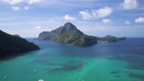 Aerial-tracking-shot-of-famous-giant-limestone-cliff-in-Bacuit-Archipelago-close-to-El-Nido-town,-Palawan,-the-Philippines-on-sunny-day