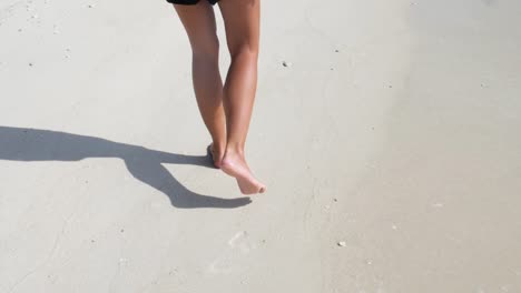 Ultra-slow-motion-shot-of-legs-and-feet-of-young-caucasian-woman-walking-on-sand-in-Thailand