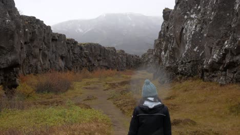 Medium-Shot-Following-a-Woman-Through-an-Icelandic-Canyon