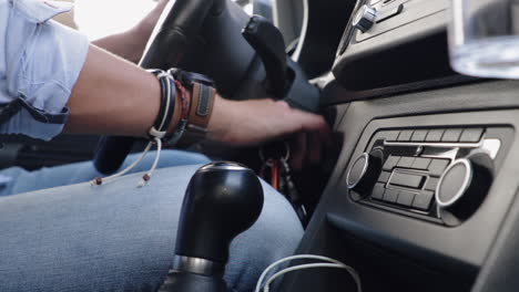 View-of-male-hand-inserting-key-in-ignition-and-starting-up-car-in-slow-motion