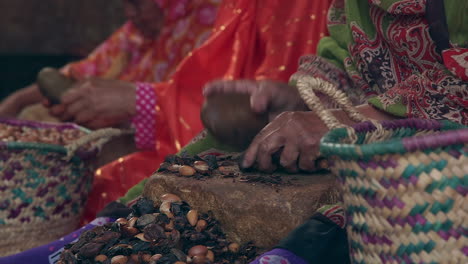 Hands-of-Many-Women-Crushing-Argan-Seeds-and-Beans-by-Stone-for-Dinner
