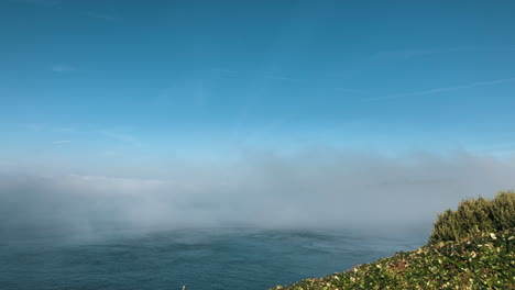 Nebel-Bildet-Sich-über-Dem-Meer,-Die-Kamera-Schwenkt-Nach-Rechts-Und-Zeigt-Die-In-Nebel-Gehüllte-Insel-Und-Die-Kreisförmige-Rotation-Des-Meeres-Aufgrund-Von-Strömungen