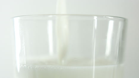 Zeitlupenaufnahmen-Von-Milch,-Die-In-Ein-Glas-Gegossen-Wird,-Wobei-Nur-Der-Obere-Teil-Des-Glases-Zu-Sehen-Ist