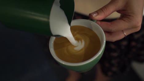 Professional-female-barista-makes-rosetta-in-cappuccino---close-up