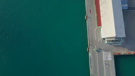 Luftaufnahme-Des-Kreuzfahrtschiffes-Im-Dock-Mit-Nach-Unten-Geneigter-Kamera,-Um-Einen-Überblick-über-Das-Blaue-Wasser-Zu-Erhalten,-4K