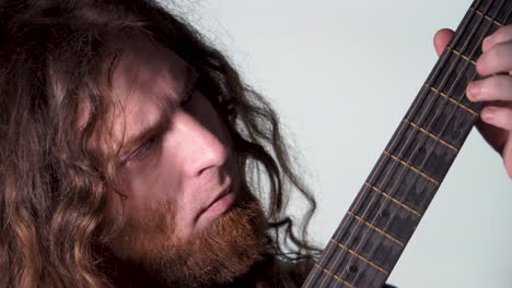 Long-Hair-beard-man-auburn-Playing-acoustic-guitar-white-light-background