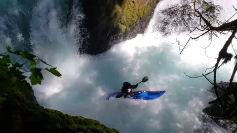 Wildwasserkajakfahrer-Fährt-über-Blauen-Wasserfall-–-Mittlere-Zeitlupenaufnahme