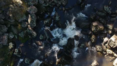 Tieffliegende-Luftaufnahme-Eines-Flusses,-Der-über-Felsen-Fließt