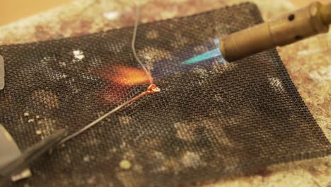 Soldering-metal-wires-with-butane-gas-flame-burner---close-up-shot-in-slow-motion