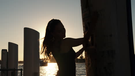 Silhouette-shot-of-beautiful-lady's-hair-on-sunset-with-water-on-background-Playing-with-the-sun-on-the-sunset