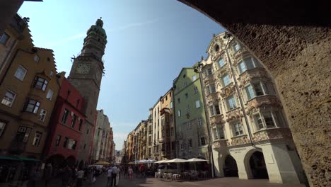 View-from-arcades-of-the-Herzog-Friedrich-Straße,-crossing-pedestrians-below-the-golden-roof