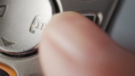 Macro-shot-of-a-finger-hanging-up-a-cordless-phone