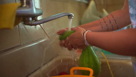 Woman-washing-squash-at-house-tap-CLOSEUP