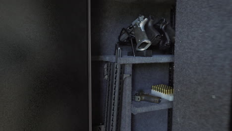Person-placing-handgun-back-in-gun-safe-and-shutting-the-vault-door