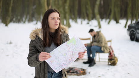 Caucasian-woman-checking-map-for-directions-in-a-snowed-forest.