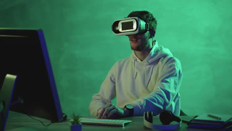 Man-using-a-VR-headset-and-a-computer-on-a-colorful-background