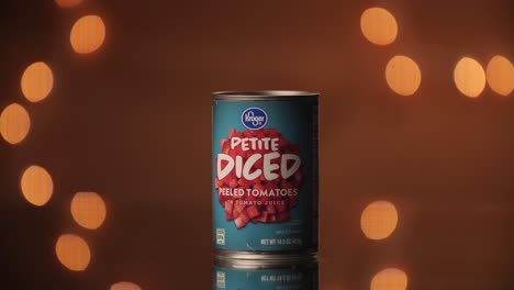 Hand-model-places-a-can-of-Kroger-petite-diced-peeled-tomatoes-on-a-table-with-a-beautiful-bokeh-backdrop