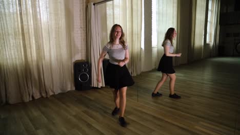 Teenage-girl-dancing-in-the-studio,-next-to-a-mirror-in-slow-motion