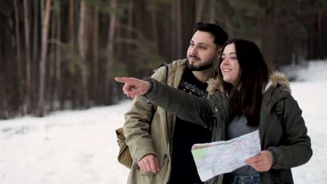 Caucasian-couple-checking-map-for-directions-in-a-snowed-forest.