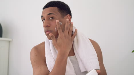 Portrait-of-a-black-male-applying-moisturizer.-Homemade-treatments-and-care.