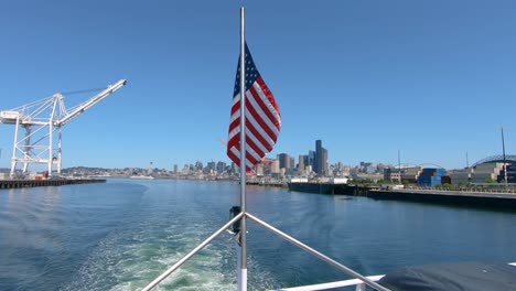 Back-of-sailing-boat-with-American-flag-and-scenic-Seatlle-sights-in-background