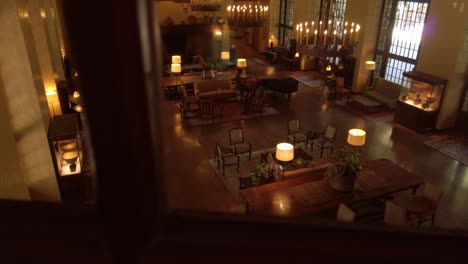 Slow-panning-shot-through-windowpane-of-an-upscale-lounge-in-a-historic-national-park-hotel-lodge