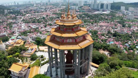 Wide-view-of-Kuan-Yin-Goddess-of-Mercy-Statue-building-in-Kek-Lok-Si-Buddhist-temple,-Aerial-drone-orbit-down-reveal-shot