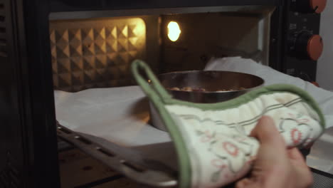 Woman-puts-a-baking-pan-into-oven