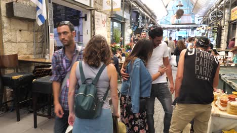 Young-woman-tourist-walk-the-Mahane-Yehuda-Market-in-Jerusalem,-Israel