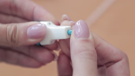 Closeup-Of-Woman's-Hand-With-A-Lancet-Stick-Removing-Its-Protective-Cap---Covid-19-Home-Test-Kit---Slow-Motion
