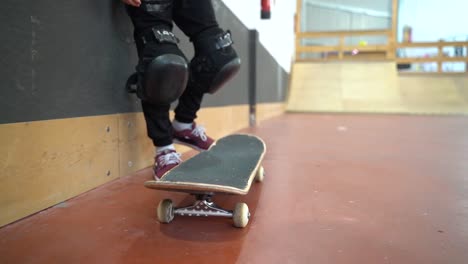 Slow-motion-low-angle-of-young-skateboarder-kicking-board-up-in-hall