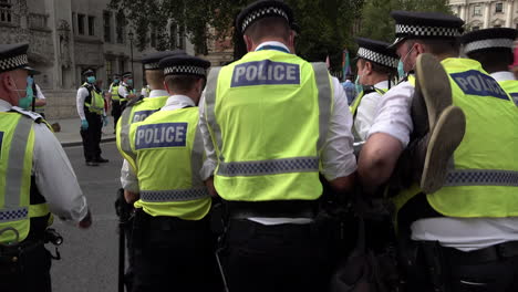 London-Metropolitan-police-officers-lift-up-and-carry-away-arrested-Extinction-Rebellion-climate-change-protestors-who-have-blocked-the-road-outside-parliament-in-Westminster