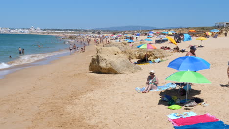 Touristen-Auf-Strandtüchern-Und-Unter-Sonnenschirmen-Am-Portugiesischen-Strand