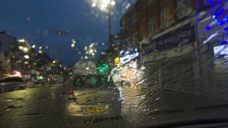 Rain-Falling-On-Parked-Car-Windscreen-At-Night-With-Cars-Driving-Past